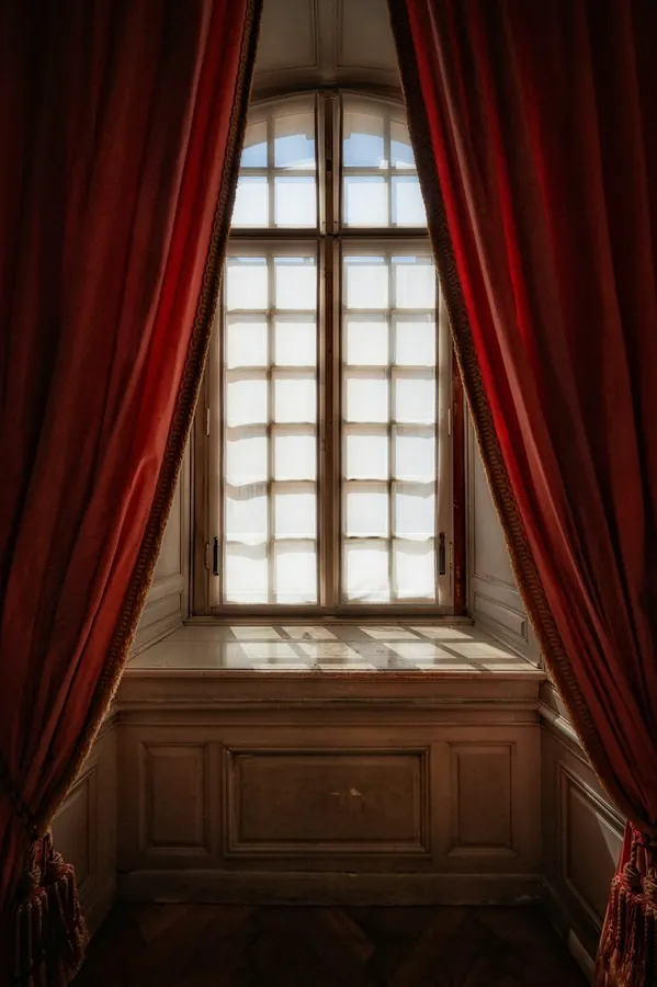 Deep red curtains framing a window