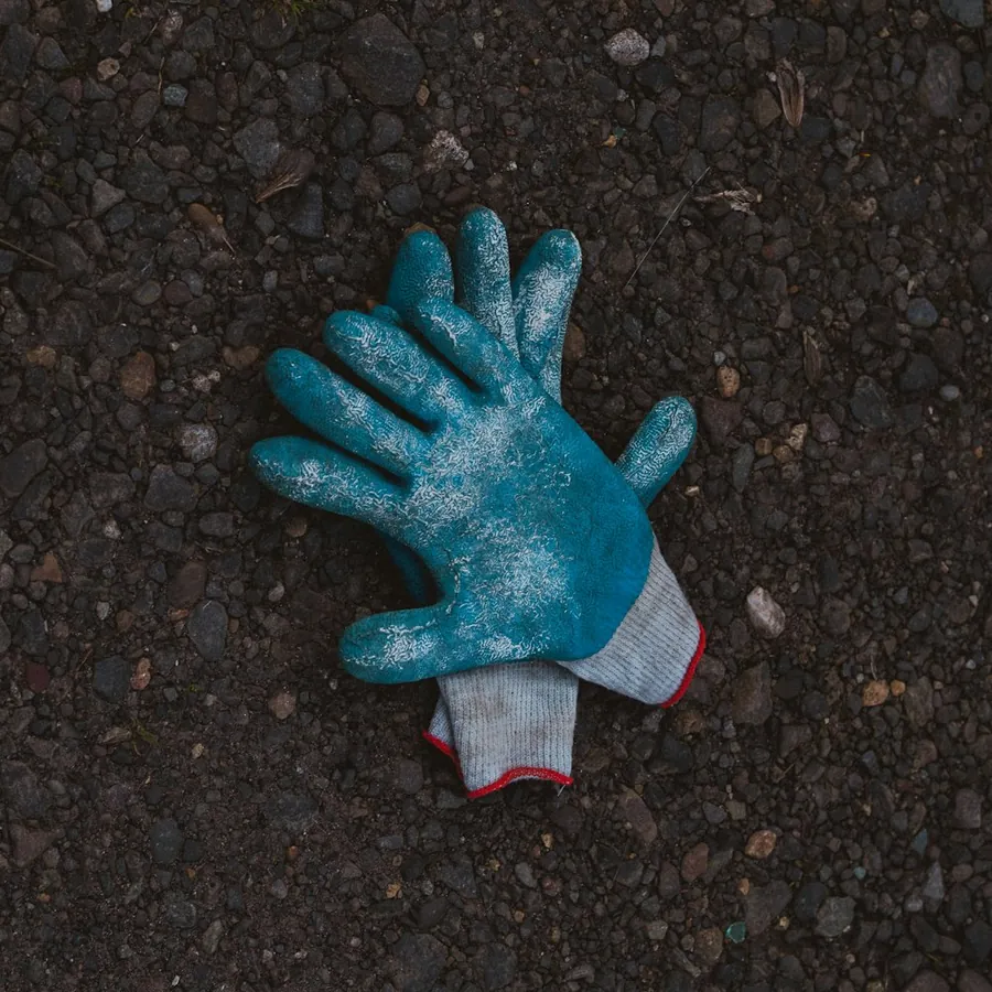 Blue coated safety glove on dark ground