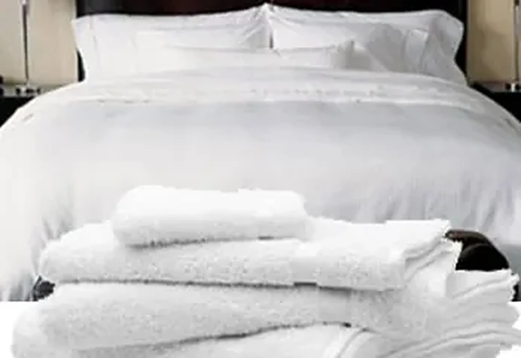 White hotel bed linen with folded white towels