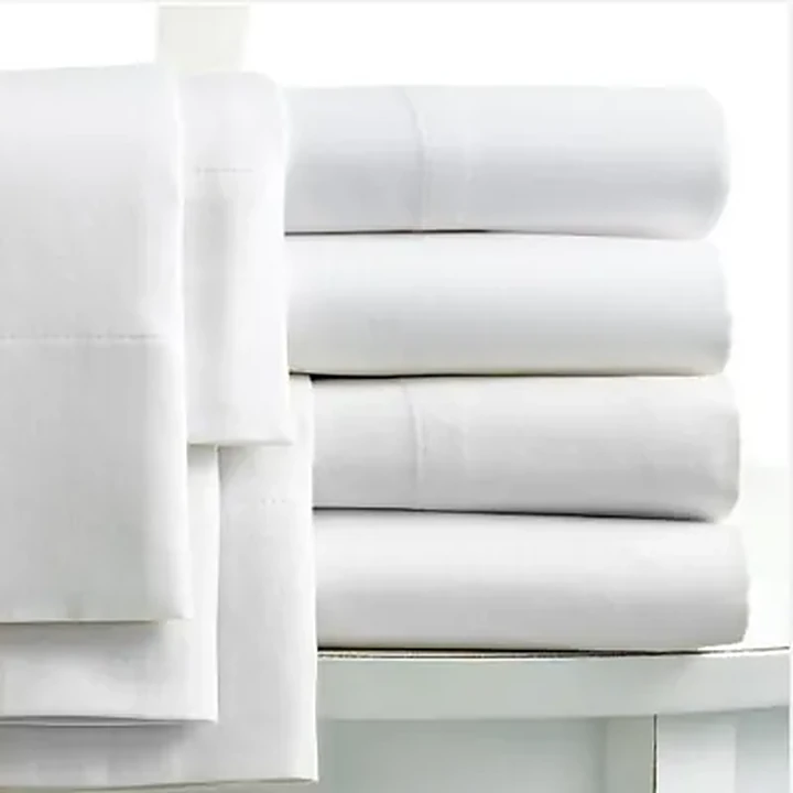 Folded white percale bed sheets