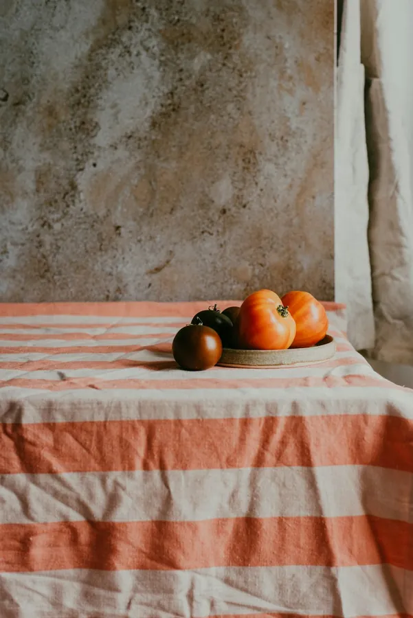 Orange and cream striped table cloth with fruit