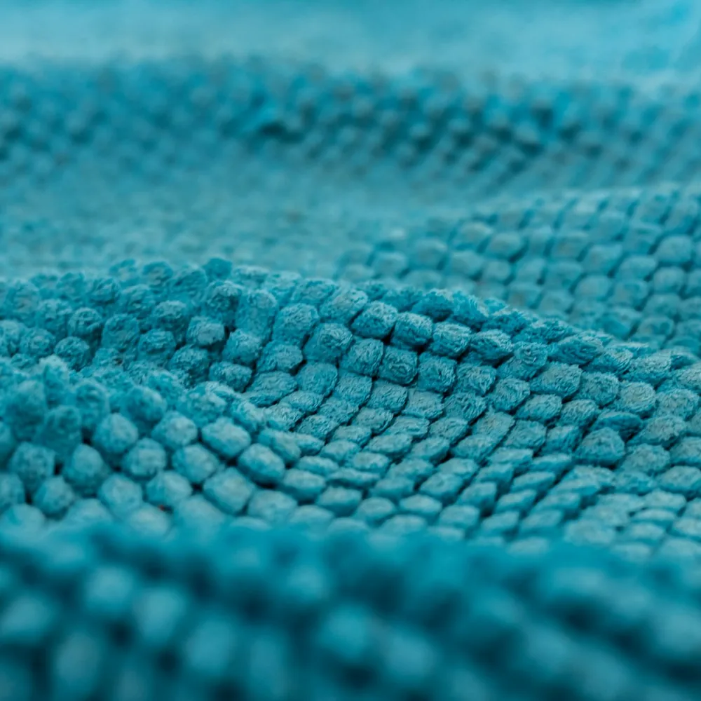 Close-up of a teal chenille bath mat