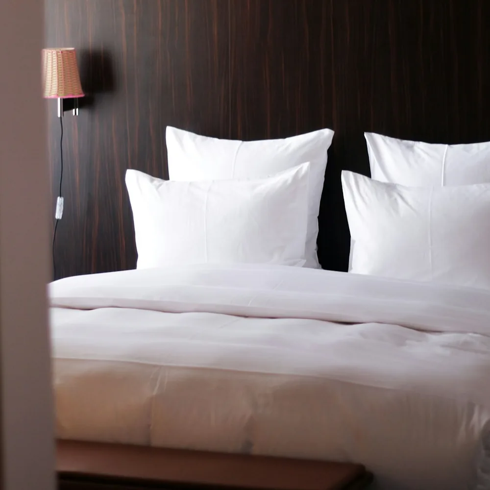 Hotel bed made up with white sheets and pillows