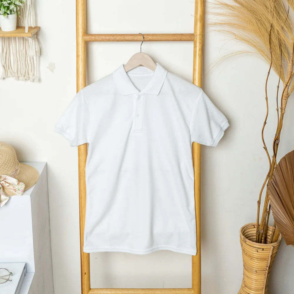 Plain white pique polo shirt on a wooden hanger